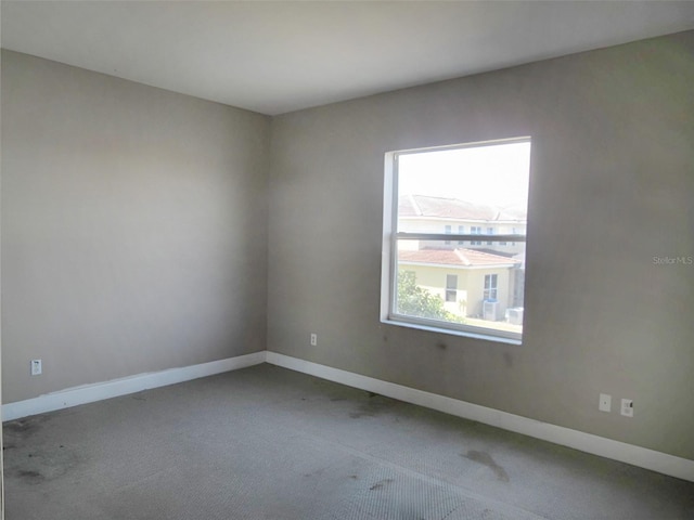 carpeted spare room with baseboards