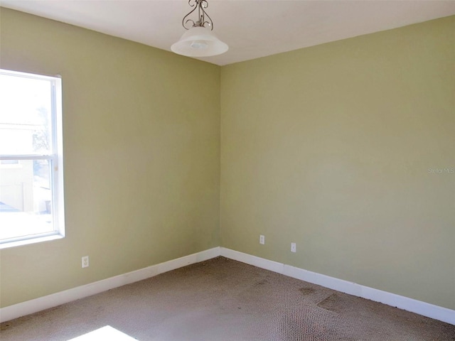 carpeted empty room with a healthy amount of sunlight and baseboards