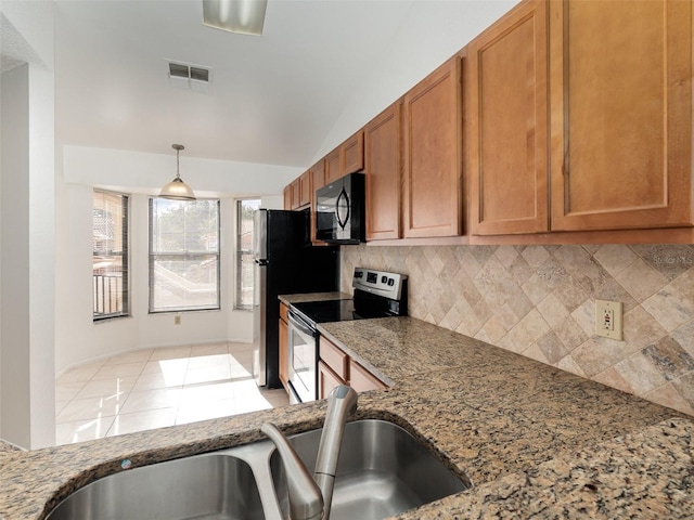 kitchen with sink, tasteful backsplash, light stone counters, hanging light fixtures, and electric stove