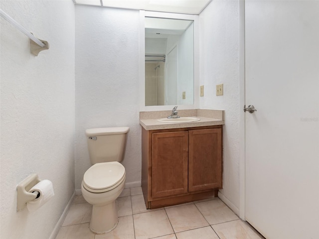 bathroom featuring tile patterned flooring, vanity, and toilet