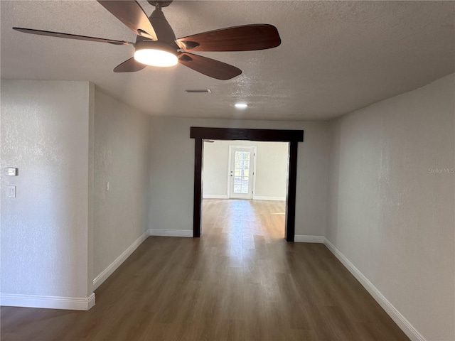 corridor with hardwood / wood-style floors and a textured ceiling