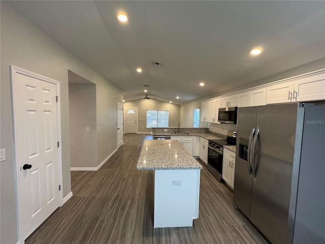 kitchen featuring white cabinetry, light stone counters, lofted ceiling, and appliances with stainless steel finishes