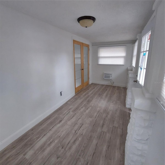 unfurnished room featuring a wall mounted air conditioner and light wood-type flooring