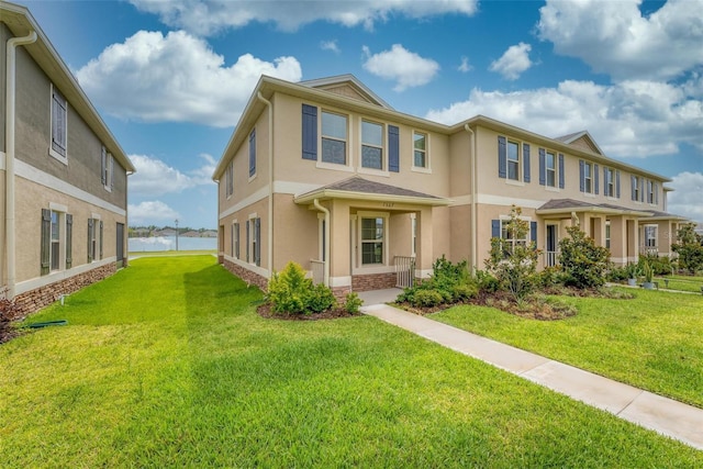 view of front of house with a front lawn and a water view