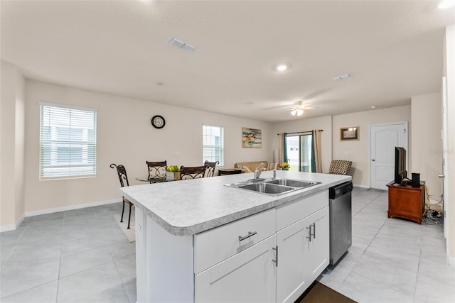 kitchen with sink, a kitchen island with sink, white cabinets, light tile patterned flooring, and stainless steel dishwasher