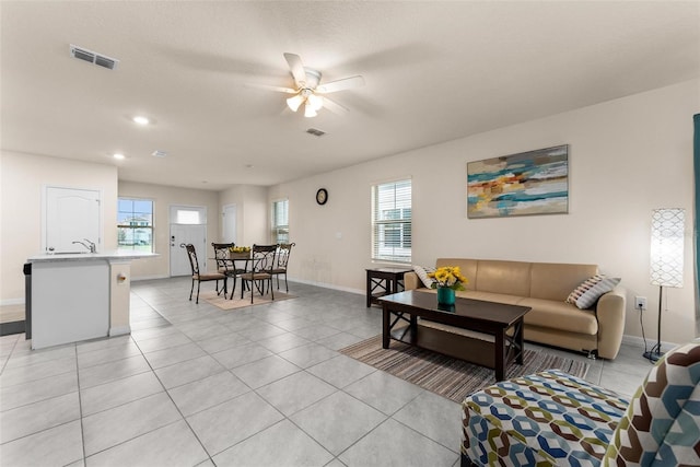 tiled living room with ceiling fan and a healthy amount of sunlight