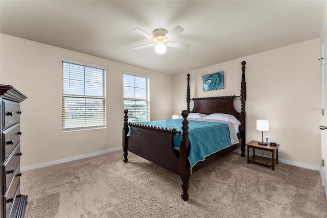 bedroom with a textured ceiling, light colored carpet, and ceiling fan