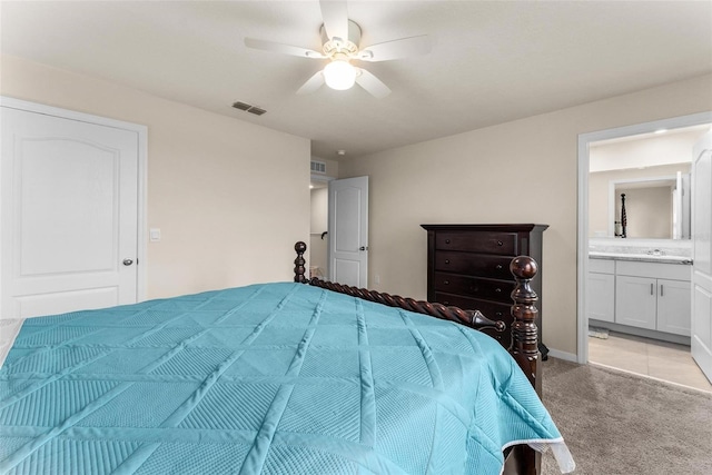 bedroom with light carpet, ceiling fan, and ensuite bathroom