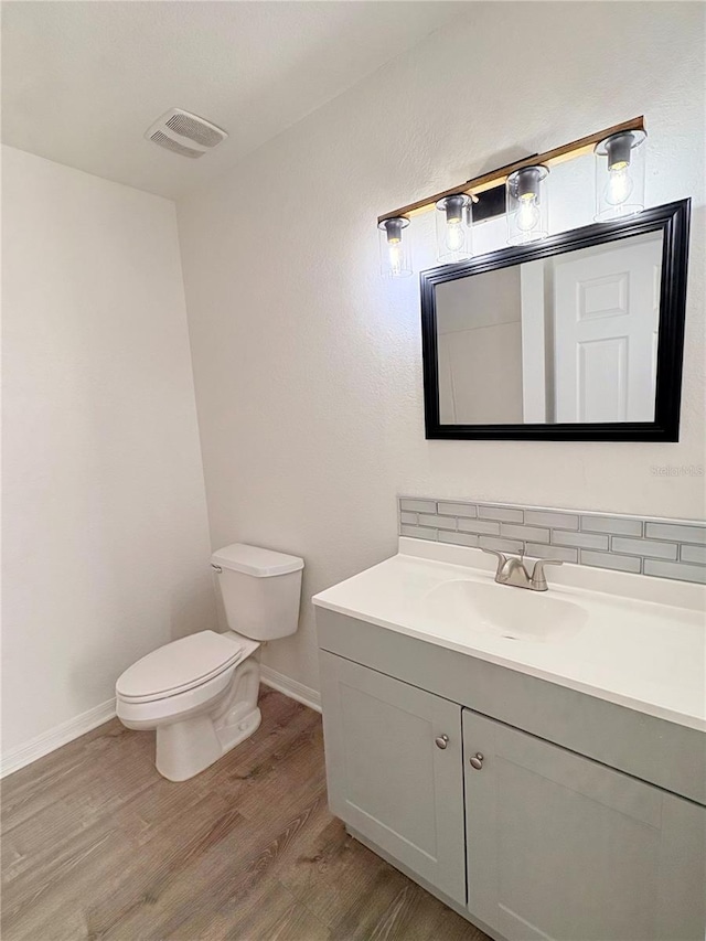 bathroom featuring hardwood / wood-style flooring, vanity, and toilet