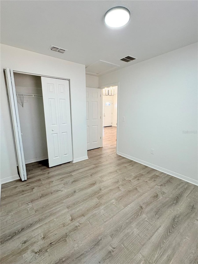 unfurnished bedroom featuring a closet and light hardwood / wood-style flooring