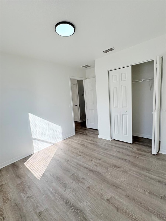 unfurnished bedroom featuring a closet and light hardwood / wood-style flooring