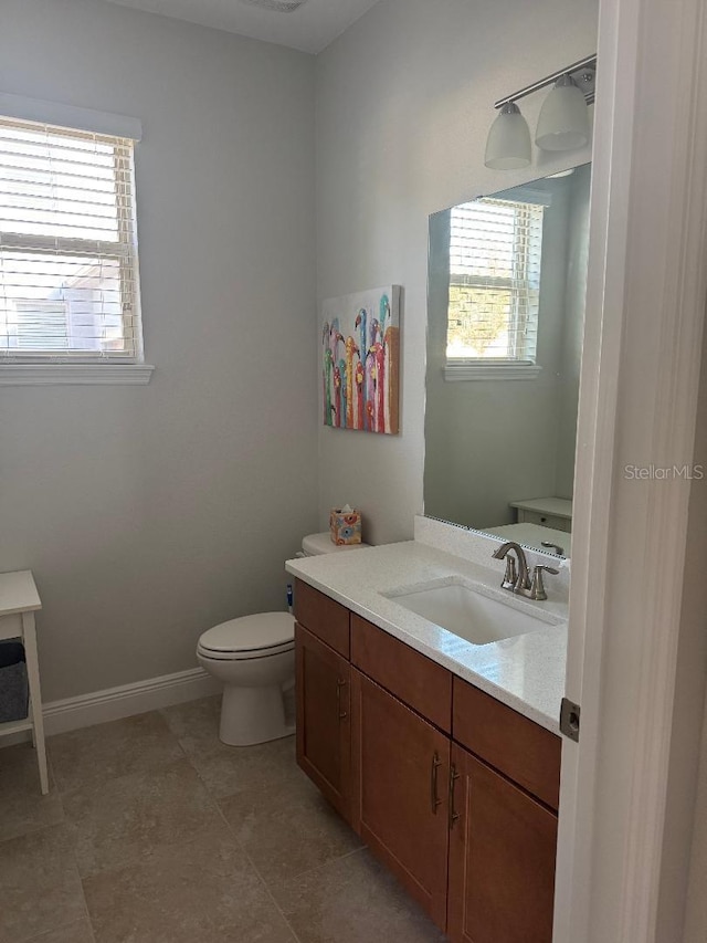 bathroom featuring tile patterned flooring, vanity, and toilet