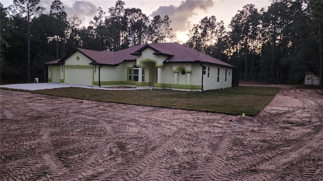 view of front of property featuring a garage and a lawn