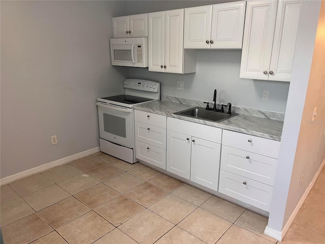 kitchen with white appliances, light tile patterned floors, sink, and white cabinets