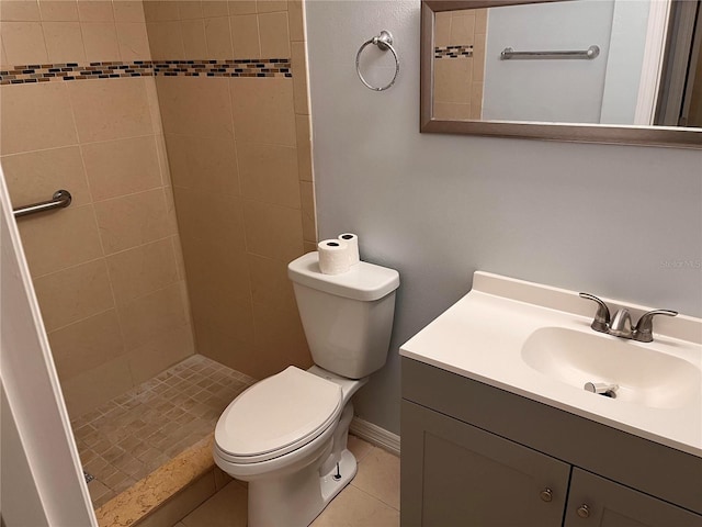 bathroom with vanity, toilet, tile patterned flooring, and a tile shower