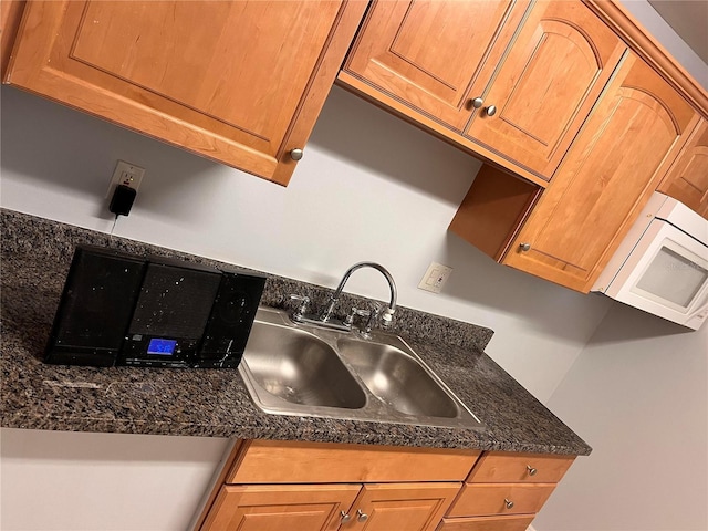 kitchen featuring dark stone countertops and sink