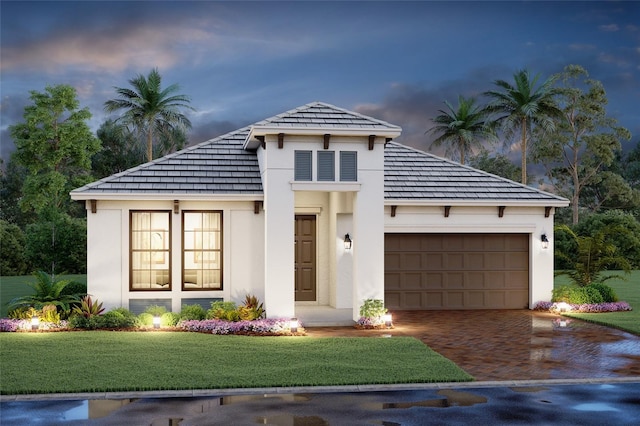 view of front of home featuring a garage and a lawn