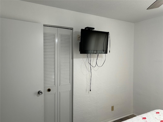 bedroom featuring a textured ceiling, a closet, and wood-type flooring