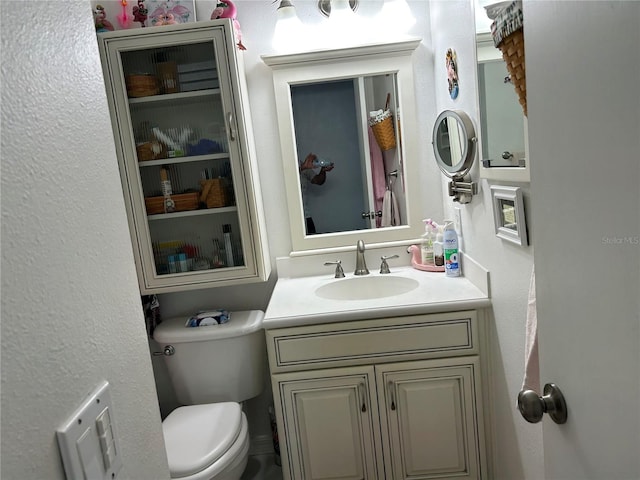 bathroom featuring toilet and vanity