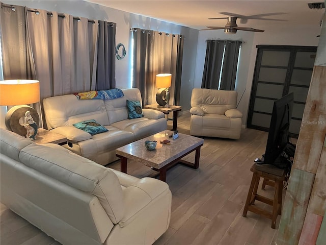 living room featuring light hardwood / wood-style flooring and ceiling fan