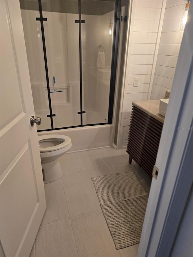 full bathroom with vanity, combined bath / shower with glass door, tile patterned floors, and toilet