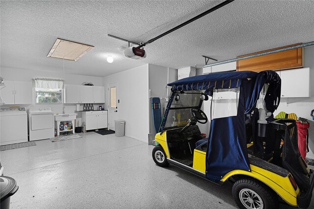 garage with washing machine and dryer and a garage door opener