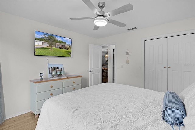 bedroom featuring light wood finished floors, a closet, baseboards, and ceiling fan