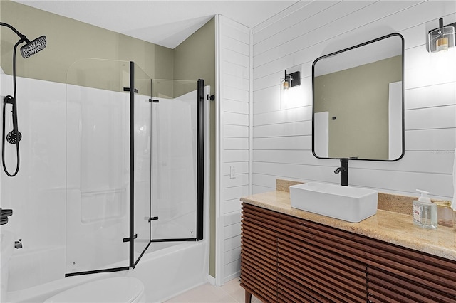 full bath with bath / shower combo with glass door, toilet, vanity, and tile patterned floors