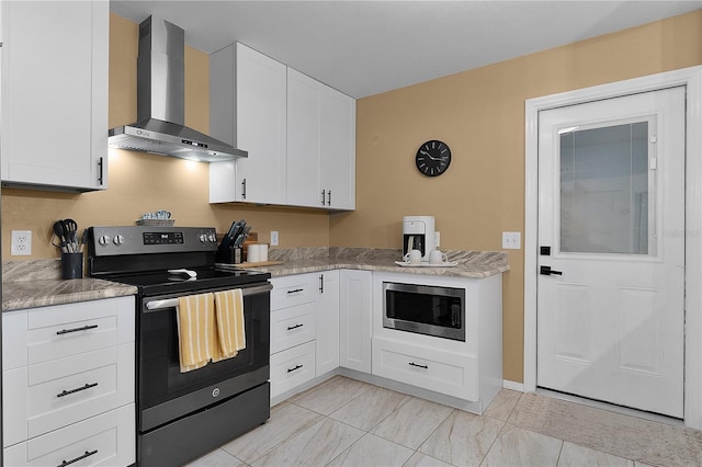 kitchen with wall chimney range hood, range with electric stovetop, stainless steel microwave, white cabinets, and light countertops