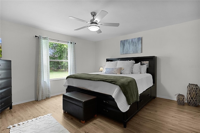 bedroom featuring light wood finished floors, baseboards, and ceiling fan