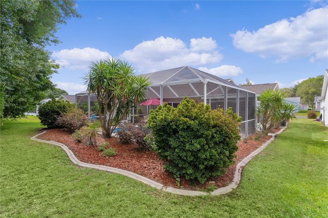 view of grassy yard featuring glass enclosure