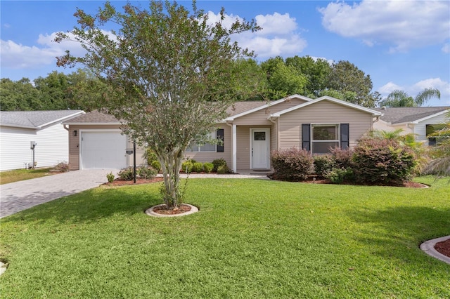 ranch-style home featuring decorative driveway, a front lawn, and an attached garage