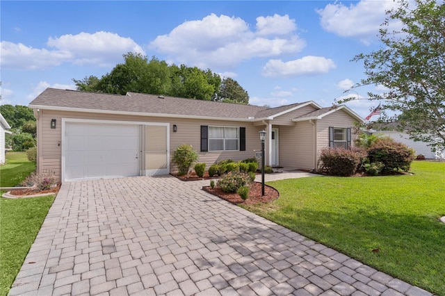 ranch-style house with an attached garage, decorative driveway, and a front yard