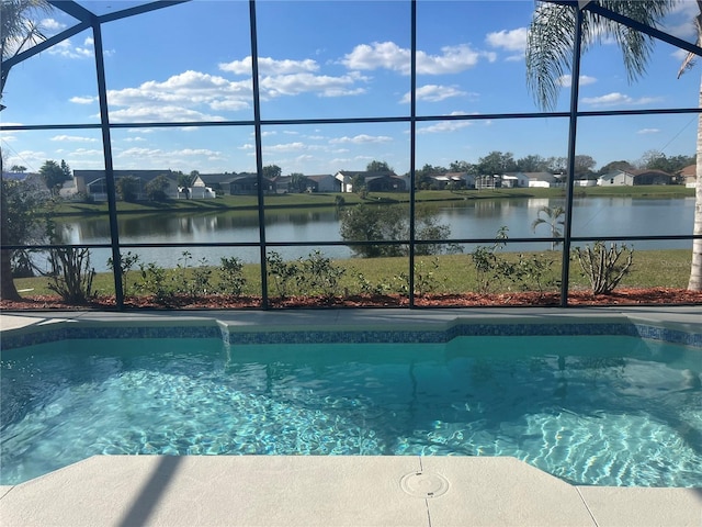 view of pool featuring a water view and glass enclosure