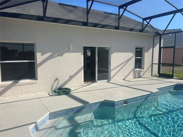 view of pool with a patio and glass enclosure