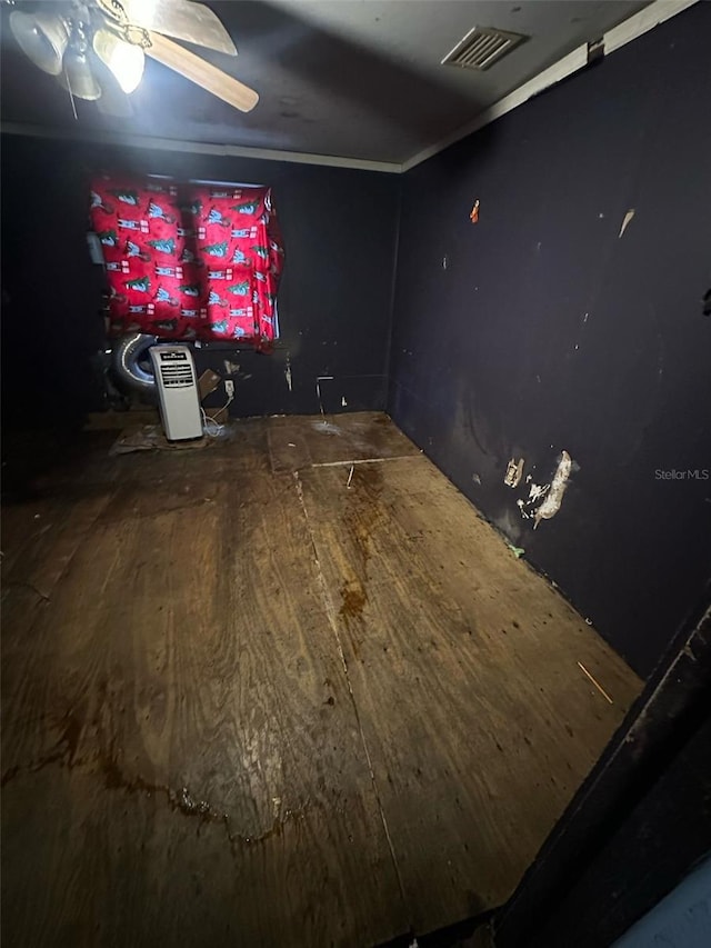 empty room with crown molding, wood-type flooring, and ceiling fan