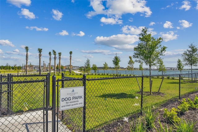 view of gate with a water view and a yard