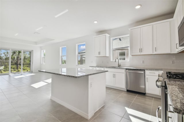 kitchen featuring tasteful backsplash, appliances with stainless steel finishes, stone countertops, and white cabinets