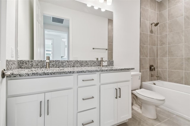 full bathroom featuring vanity, tile patterned floors, toilet, and tiled shower / bath