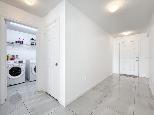 washroom with light tile patterned floors and washer and clothes dryer