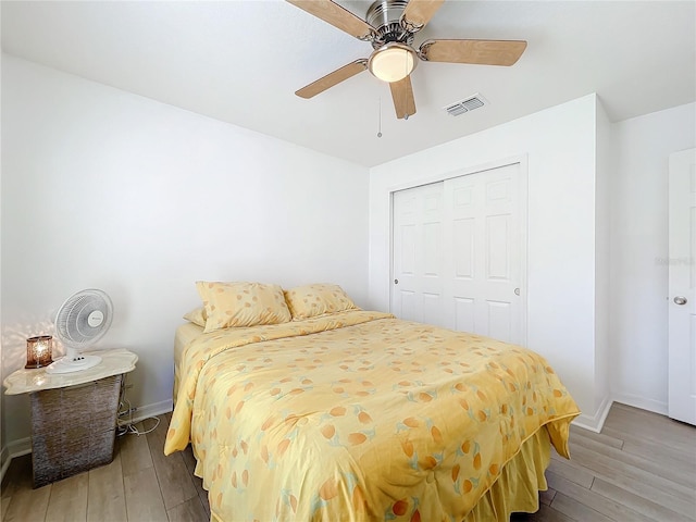 bedroom featuring ceiling fan, wood-type flooring, and a closet