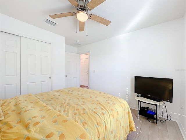 bedroom with light hardwood / wood-style flooring, a closet, and ceiling fan