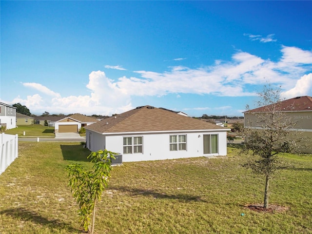 back of house featuring a garage and a lawn