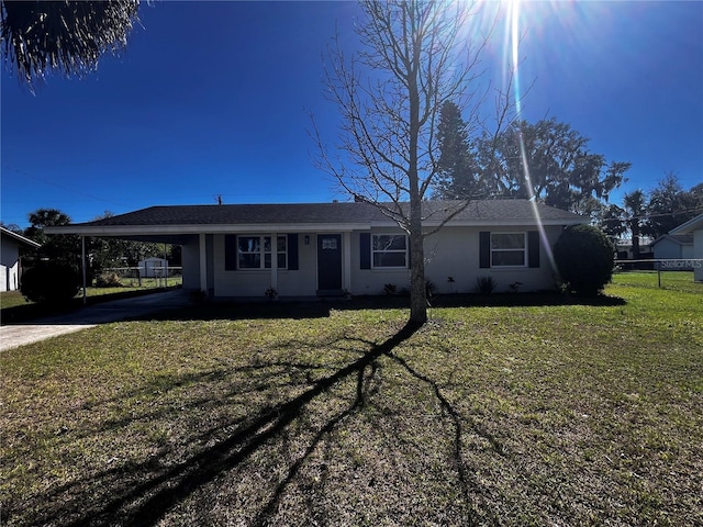 ranch-style home featuring a front lawn and a carport