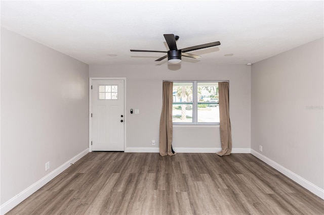foyer entrance with ceiling fan, baseboards, and wood finished floors