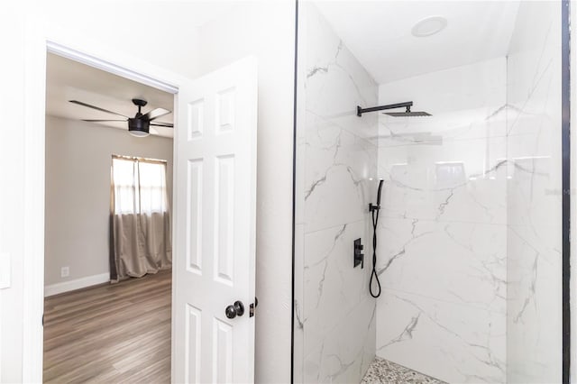 bathroom with ceiling fan, wood finished floors, a marble finish shower, and baseboards