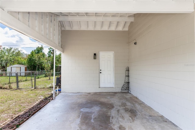 doorway to property featuring a patio area, concrete block siding, and fence
