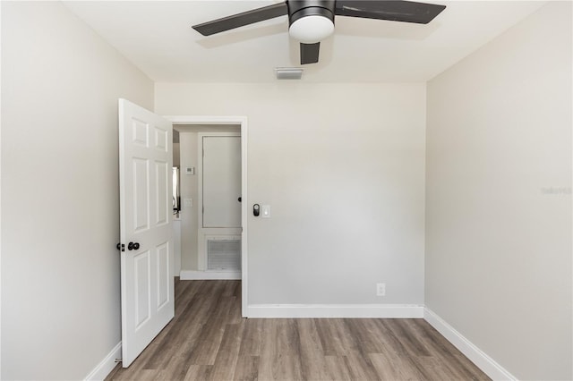 unfurnished room featuring a ceiling fan, visible vents, baseboards, and wood finished floors