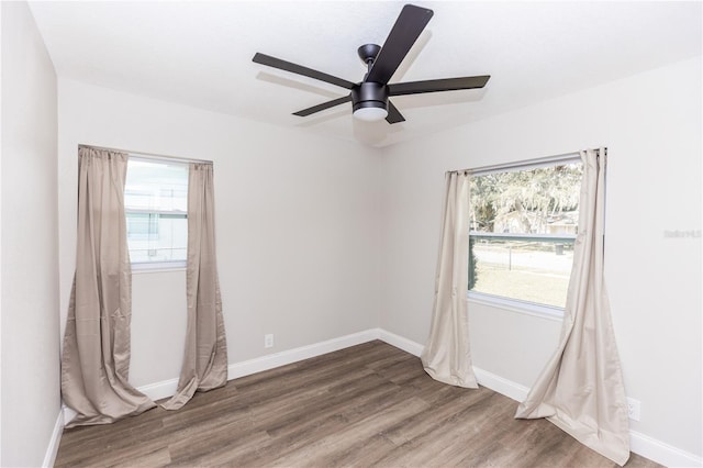 unfurnished room with a ceiling fan, baseboards, and wood finished floors