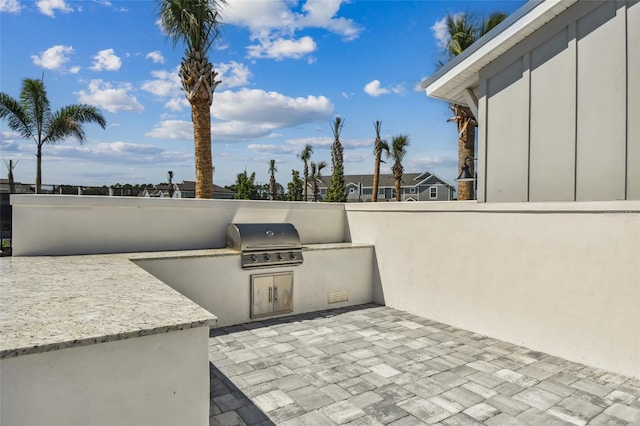 view of patio / terrace featuring an outdoor kitchen and a grill